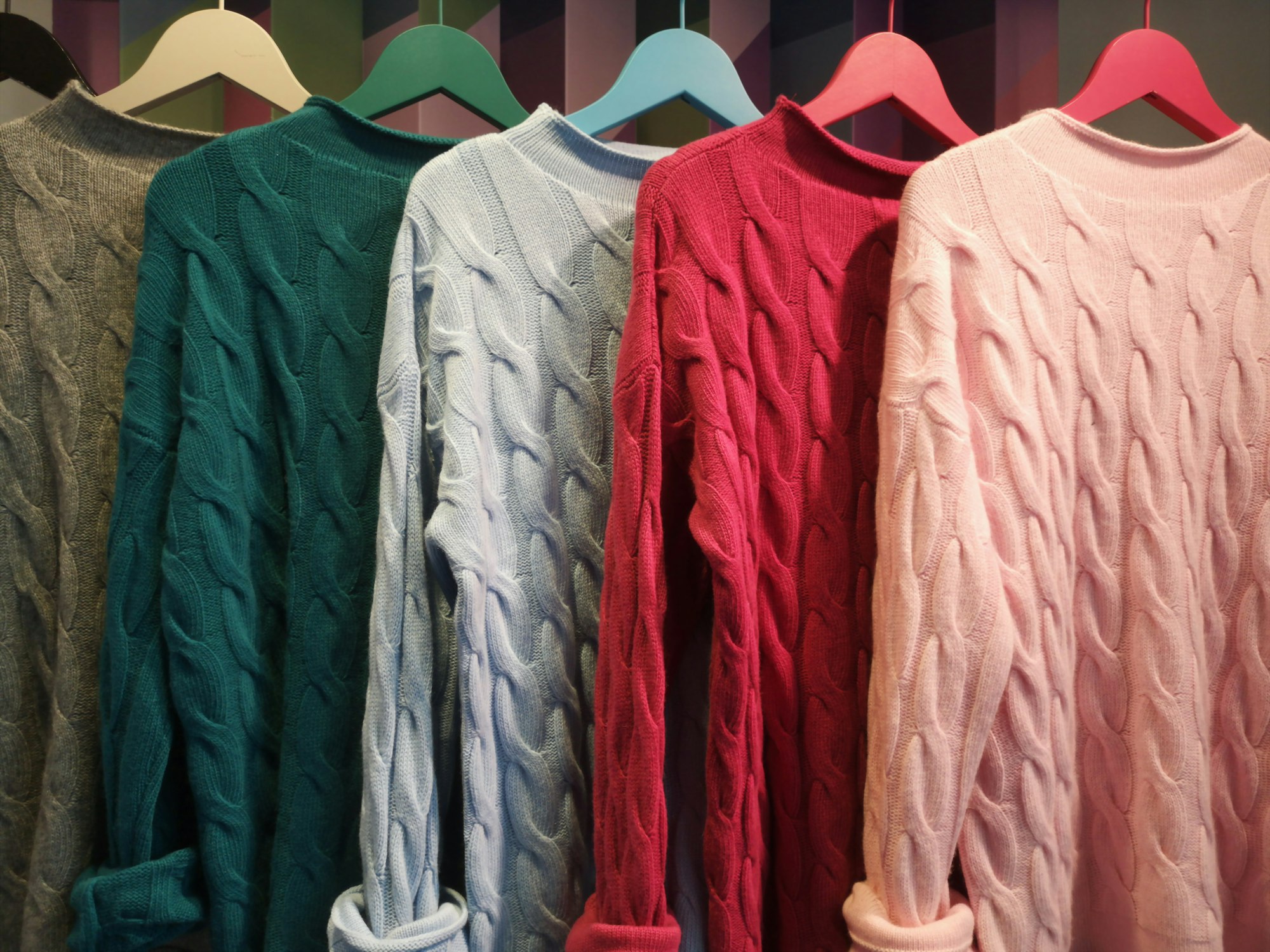 Row of the colorful, comfortable woolen sweaters in the shop