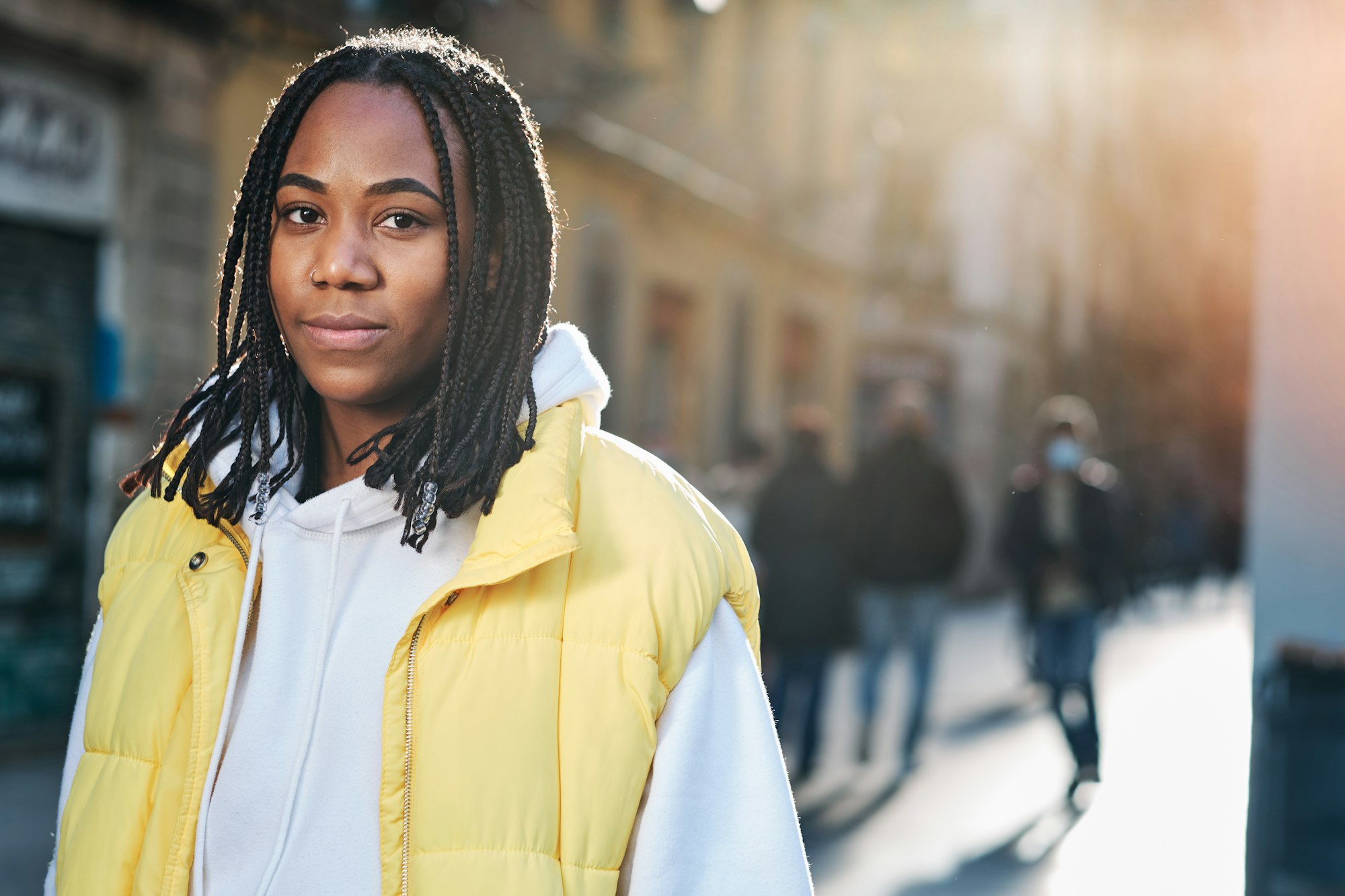 Woman looking to the camera outdoors on the street.